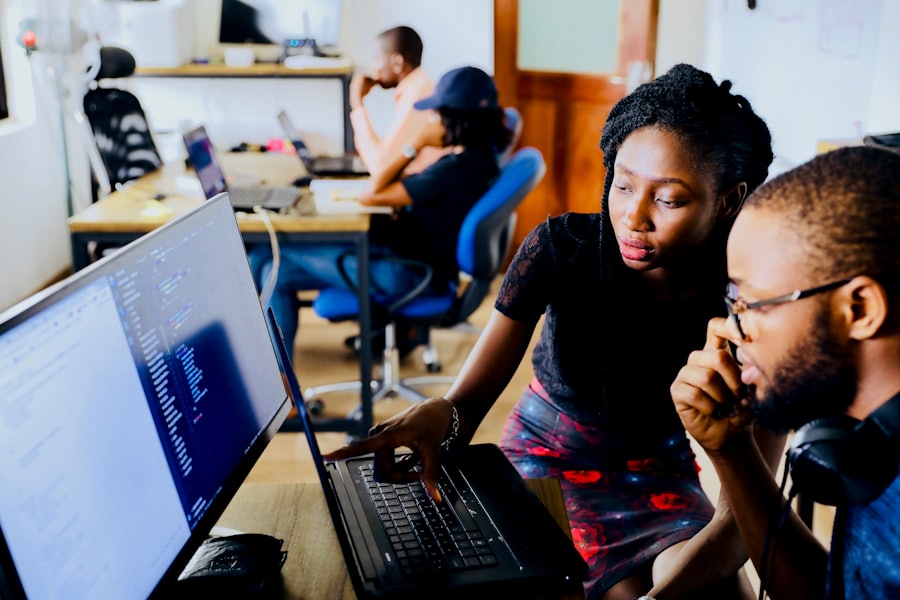 Two engineers reviewing code together on a desktop monitor